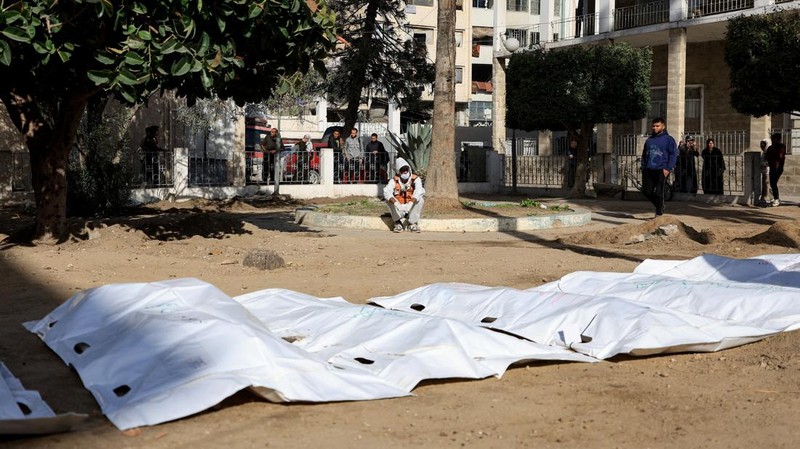 nggota Pertahanan Sipil Palestina menggali kembali jenazah orang-orang yang tewas selama perang untuk dimakamkan kembali, di Rumah Sakit Al-Ahli di Kota Gaza, Minggu (7/12/2025). (REUTERS/Dawoud Abu Alkas)