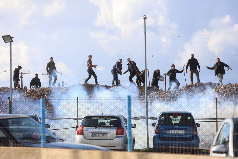 Greek farmers protesting over the delayed payment of European Union subsidies hurl stones amid tear gas at the Heraklion International Airport, in Heraklion, Crete island, Greece, December 8, 2025. REUTERS/Stefanos Rapanis     TPX IMAGES OF THE DAY