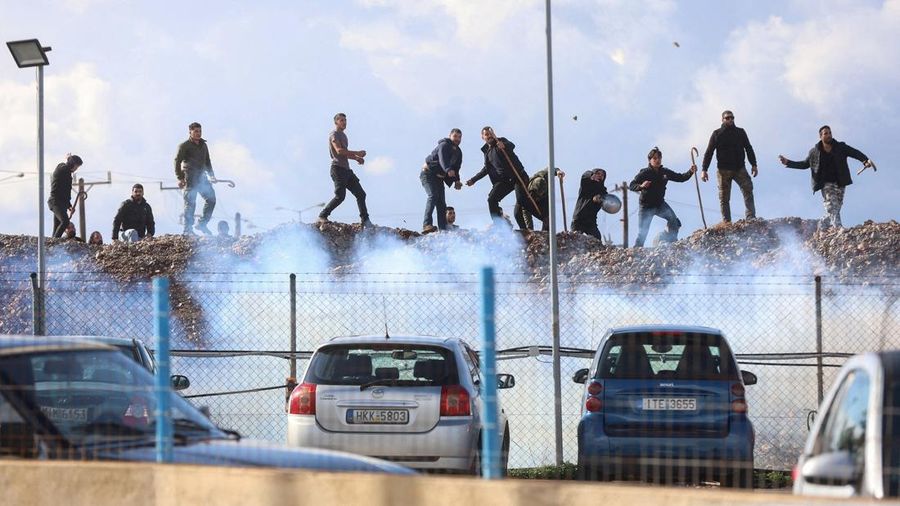 Greek farmers protesting over the delayed payment of European Union subsidies hurl stones amid tear gas at the Heraklion International Airport, in Heraklion, Crete island, Greece, December 8, 2025. REUTERS/Stefanos Rapanis     TPX IMAGES OF THE DAY