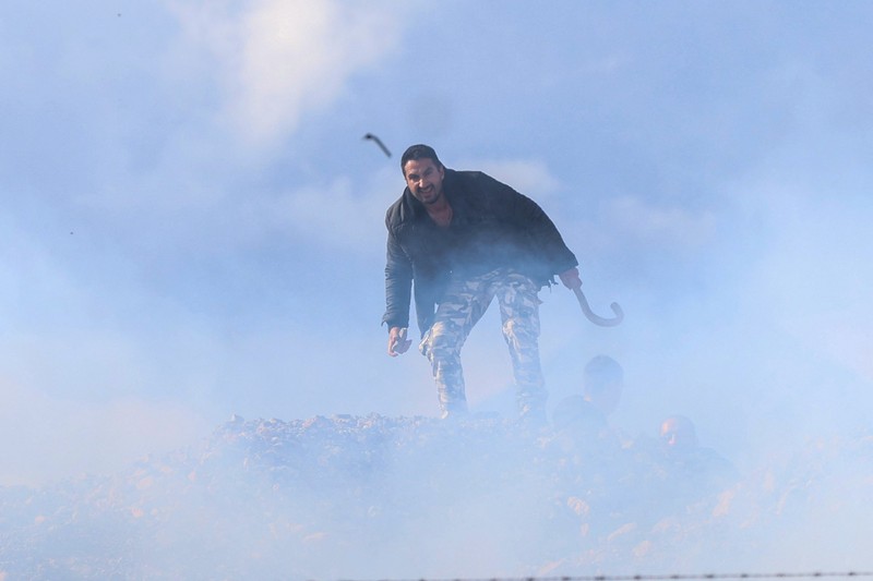 Greek farmers protesting over the delayed payment of European Union subsidies hurl stones amid tear gas at the Heraklion International Airport, in Heraklion, Crete island, Greece, December 8, 2025. REUTERS/Stefanos Rapanis     TPX IMAGES OF THE DAY