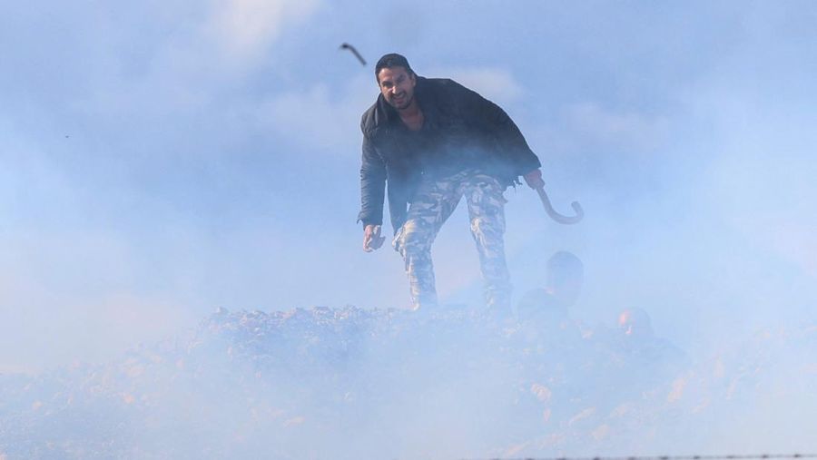 Greek farmers protesting over the delayed payment of European Union subsidies hurl stones amid tear gas at the Heraklion International Airport, in Heraklion, Crete island, Greece, December 8, 2025. REUTERS/Stefanos Rapanis     TPX IMAGES OF THE DAY