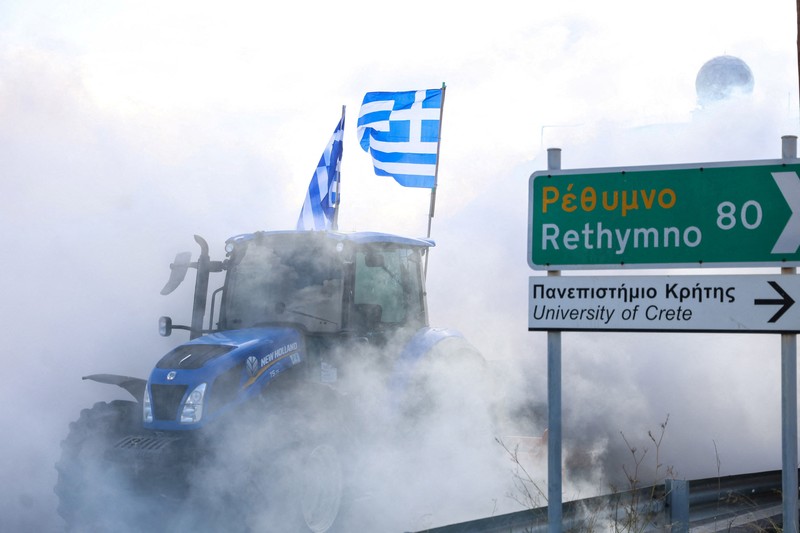 Greek farmers protesting over the delayed payment of European Union subsidies hurl stones amid tear gas at the Heraklion International Airport, in Heraklion, Crete island, Greece, December 8, 2025. REUTERS/Stefanos Rapanis     TPX IMAGES OF THE DAY