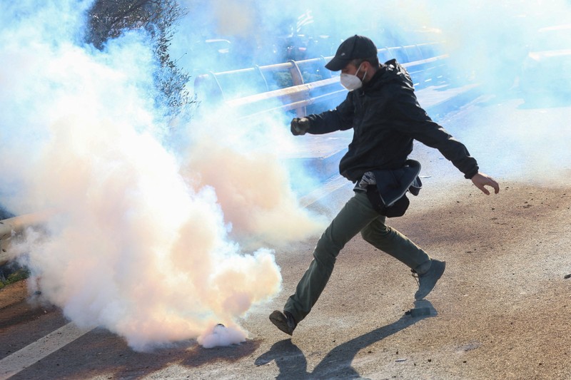 Greek farmers protesting over the delayed payment of European Union subsidies hurl stones amid tear gas at the Heraklion International Airport, in Heraklion, Crete island, Greece, December 8, 2025. REUTERS/Stefanos Rapanis     TPX IMAGES OF THE DAY