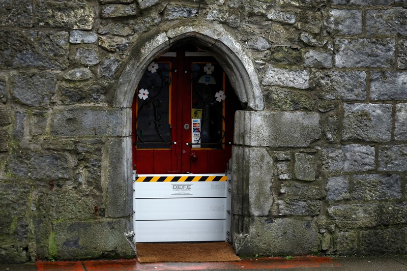 A worker holds a hose as he prepares a flood barrier defence system at the Spanish Arch, as storm named Bram approaches, in Galway, Ireland, December 9, 2025. REUTERS/Clodagh Kilcoyne