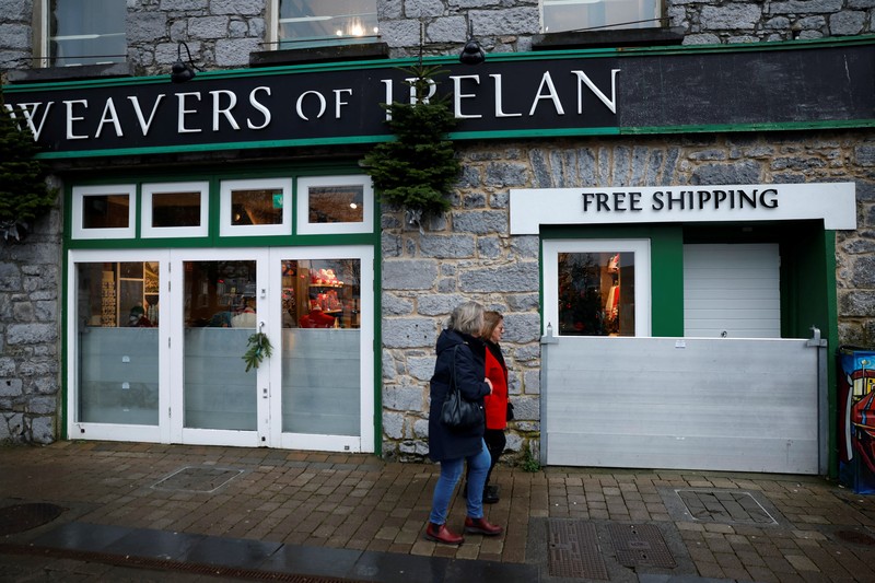 A worker holds a hose as he prepares a flood barrier defence system at the Spanish Arch, as storm named Bram approaches, in Galway, Ireland, December 9, 2025. REUTERS/Clodagh Kilcoyne