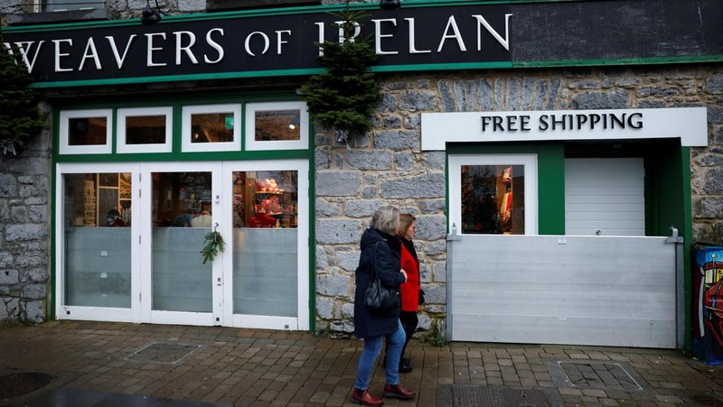 A worker holds a hose as he prepares a flood barrier defence system at the Spanish Arch, as storm named Bram approaches, in Galway, Ireland, December 9, 2025. REUTERS/Clodagh Kilcoyne