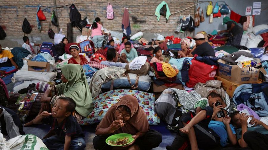 Penduduk desa beristirahat di dalam gudang yang digunakan sebagai tempat penampungan sementara setelah banjir bandang mematikan di Batang Toru, Tapanuli Selatan, provinsi Sumatera Utara, Indonesia, 7 Desember 2025. (REUTERS/Willy Kurniawan)