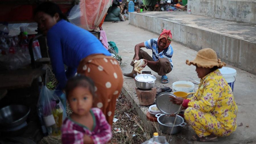 Seseorang menggendong seorang anak di kamp pengungsi setelah evakuasi, di tengah bentrokan mematikan antara Thailand dan Kamboja di sepanjang wilayah perbatasan yang disengketakan, di Srei Snam, Provinsi Siem Reap, Kamboja, 10 Desember 2025. (REUTERS/Kim Hong-Ji)