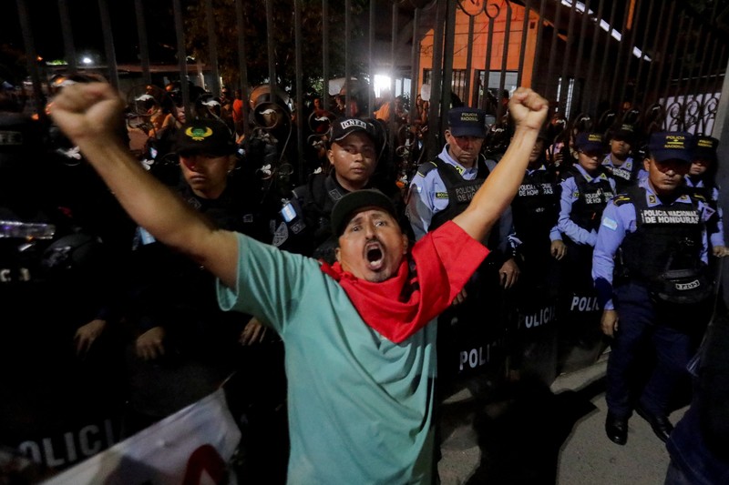 Seorang pendukung pemerintah membawa ban selama protes di luar instalasi Dewan Pemilihan Nasional (CNE) tempat penyimpanan perlengkapan pemilu, setelah Presiden Honduras Xiomara Castro mengecam apa yang disebutnya sebagai