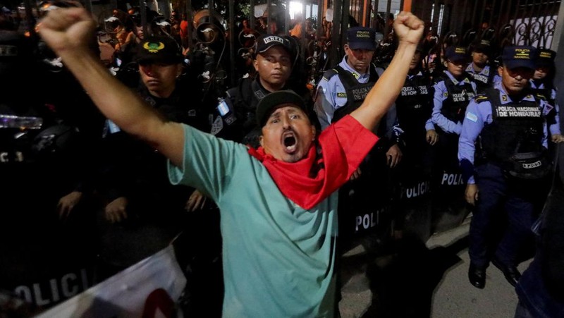 Seorang pendukung pemerintah membawa ban selama protes di luar instalasi Dewan Pemilihan Nasional (CNE) tempat penyimpanan perlengkapan pemilu, setelah Presiden Honduras Xiomara Castro mengecam apa yang disebutnya sebagai 