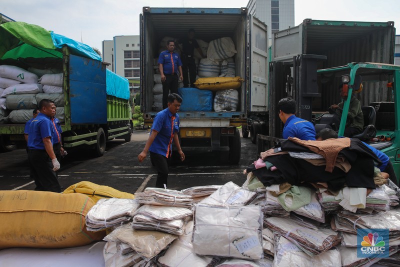 Petugas memindahkan produk garmen ilegal saat Ekspose Barang Hasil Penindakan di Kantor Pusat Bea dan Cukai Rawamangun, Jakarta, Kamis (11/12/2025). Direktorat Jenderal Bea dan Cukai (DJBC) menggagalkan upaya peredaran produk garmen ilegal melalui dua operasi penindakan yang dilakukan secara terpisah. (CNBC Indonesia/Faisal Rahman)