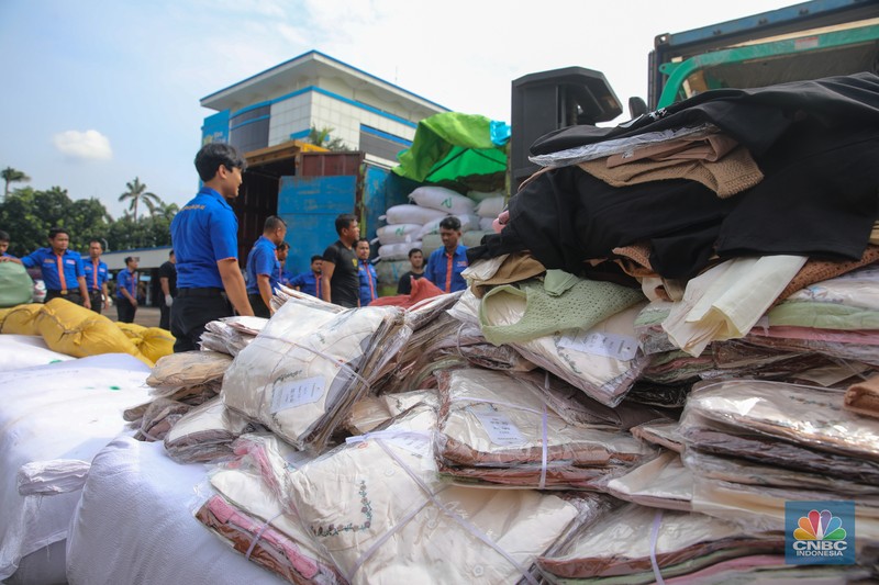 Petugas memindahkan produk garmen ilegal saat Ekspose Barang Hasil Penindakan di Kantor Pusat Bea dan Cukai Rawamangun, Jakarta, Kamis (11/12/2025). Direktorat Jenderal Bea dan Cukai (DJBC) menggagalkan upaya peredaran produk garmen ilegal melalui dua operasi penindakan yang dilakukan secara terpisah. (CNBC Indonesia/Faisal Rahman)