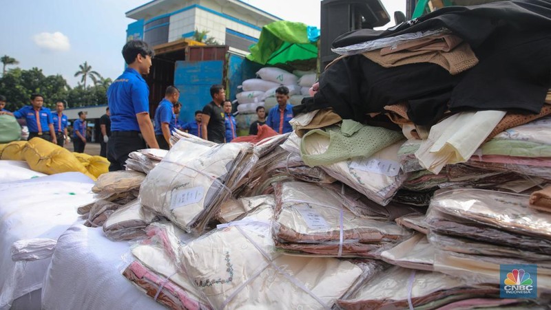 Petugas memindahkan produk garmen ilegal saat Ekspose Barang Hasil Penindakan di Kantor Pusat Bea dan Cukai Rawamangun, Jakarta, Kamis (11/12/2025). Direktorat Jenderal Bea dan Cukai (DJBC) menggagalkan upaya peredaran produk garmen ilegal melalui dua operasi penindakan yang dilakukan secara terpisah. (CNBC Indonesia/Faisal Rahman)