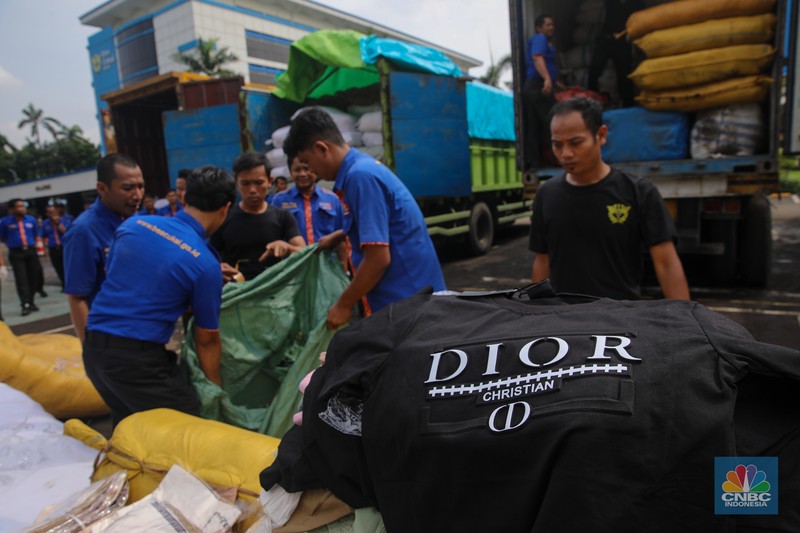Petugas memindahkan produk garmen ilegal saat Ekspose Barang Hasil Penindakan di Kantor Pusat Bea dan Cukai Rawamangun, Jakarta, Kamis (11/12/2025). Direktorat Jenderal Bea dan Cukai (DJBC) menggagalkan upaya peredaran produk garmen ilegal melalui dua operasi penindakan yang dilakukan secara terpisah. (CNBC Indonesia/Faisal Rahman)