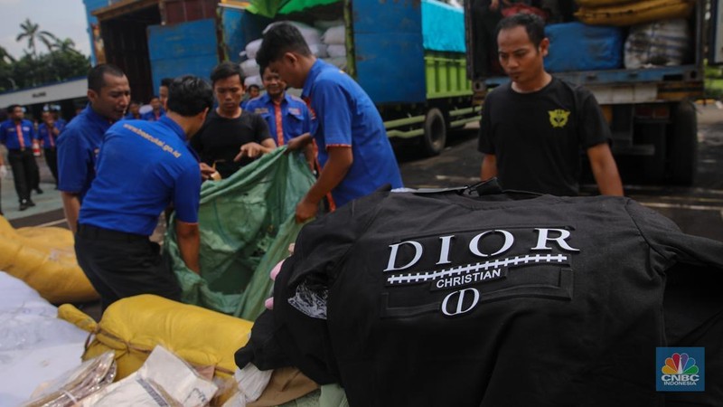 Petugas memindahkan produk garmen ilegal saat Ekspose Barang Hasil Penindakan di Kantor Pusat Bea dan Cukai Rawamangun, Jakarta, Kamis (11/12/2025). Direktorat Jenderal Bea dan Cukai (DJBC) menggagalkan upaya peredaran produk garmen ilegal melalui dua operasi penindakan yang dilakukan secara terpisah. (CNBC Indonesia/Faisal Rahman)