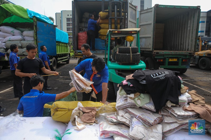 Petugas memindahkan produk garmen ilegal saat Ekspose Barang Hasil Penindakan di Kantor Pusat Bea dan Cukai Rawamangun, Jakarta, Kamis (11/12/2025). Direktorat Jenderal Bea dan Cukai (DJBC) menggagalkan upaya peredaran produk garmen ilegal melalui dua operasi penindakan yang dilakukan secara terpisah. (CNBC Indonesia/Faisal Rahman)