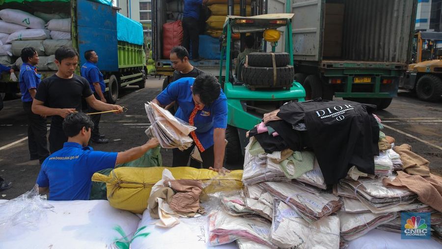 Petugas memindahkan produk garmen ilegal saat Ekspose Barang Hasil Penindakan di Kantor Pusat Bea dan Cukai Rawamangun, Jakarta, Kamis (11/12/2025). Direktorat Jenderal Bea dan Cukai (DJBC) menggagalkan upaya peredaran produk garmen ilegal melalui dua operasi penindakan yang dilakukan secara terpisah. (CNBC Indonesia/Faisal Rahman)