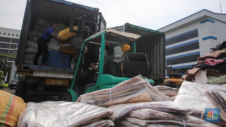 Petugas memindahkan produk garmen ilegal saat Ekspose Barang Hasil Penindakan di Kantor Pusat Bea dan Cukai Rawamangun, Jakarta, Kamis (11/12/2025). Direktorat Jenderal Bea dan Cukai (DJBC) menggagalkan upaya peredaran produk garmen ilegal melalui dua operasi penindakan yang dilakukan secara terpisah. (CNBC Indonesia/Faisal Rahman)