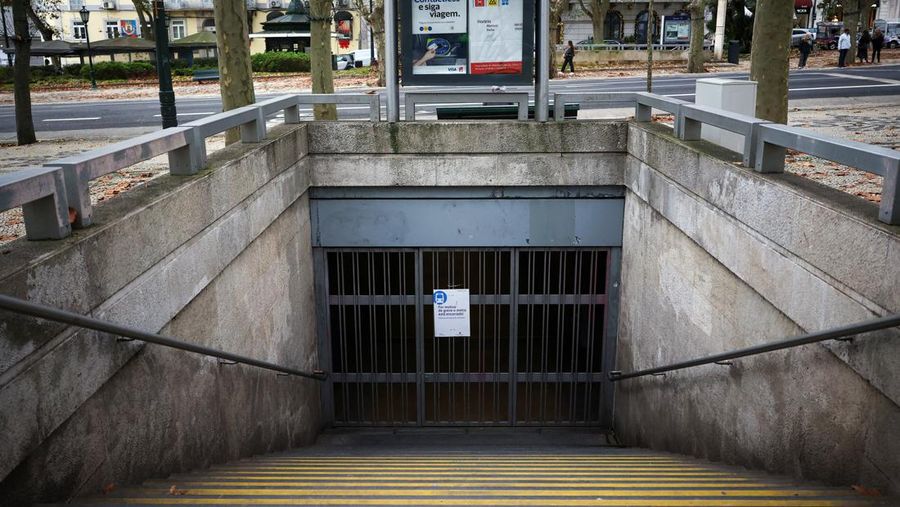 Orang-orang berjalan melewati loket tiket yang tutup di stasiun kereta api Entrecampos pada hari ketika dua serikat pekerja utama, CGTP dan UGT, menyerukan pemogokan umum sebagai protes terhadap rencana pemerintah untuk mereformasi undang-undang ketenagakerjaan, di Lisbon, Portugal, 11 Desember 2025. (REUTERS/Pedro Nunes)