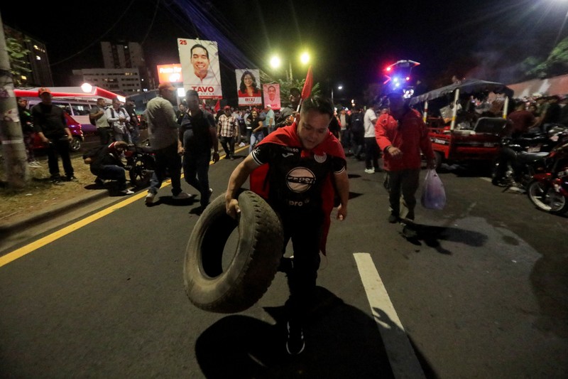Seorang pendukung pemerintah membawa ban selama protes di luar instalasi Dewan Pemilihan Nasional (CNE) tempat penyimpanan perlengkapan pemilu, setelah Presiden Honduras Xiomara Castro mengecam apa yang disebutnya sebagai