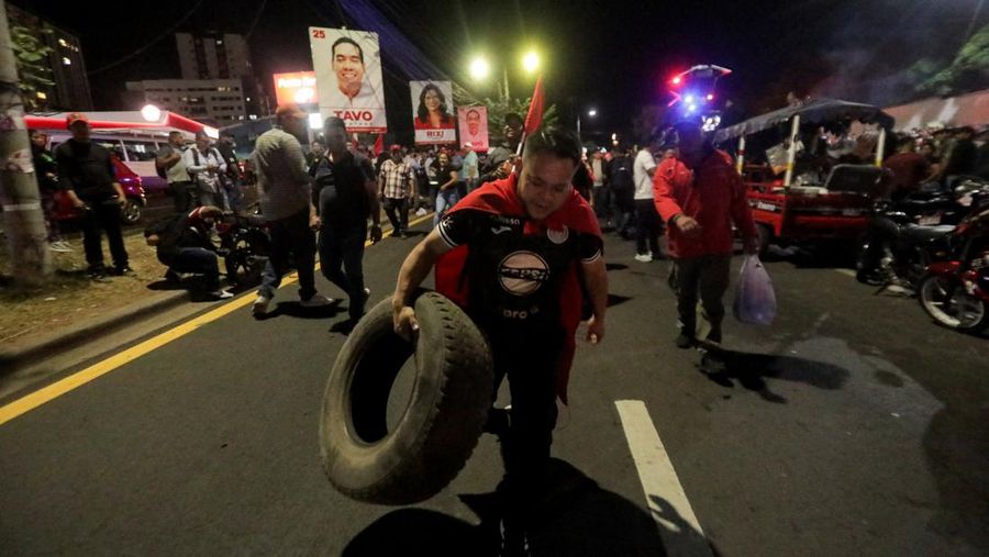 Seorang pendukung pemerintah membawa ban selama protes di luar instalasi Dewan Pemilihan Nasional (CNE) tempat penyimpanan perlengkapan pemilu, setelah Presiden Honduras Xiomara Castro mengecam apa yang disebutnya sebagai 
