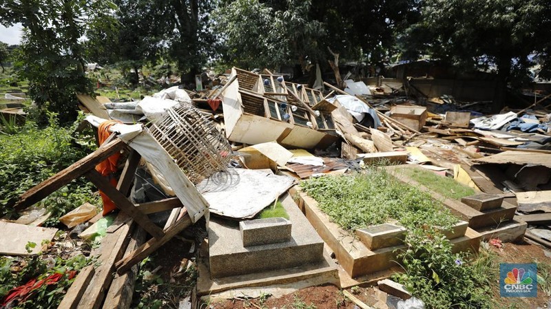 Seorang warga beraktivitas di lokasi puing-puing rumah semi permanen di TPU Menteng Pulo, Jakarta, Jumat (12/12/2025). (CNBC Indonesia/Tri Susilo)