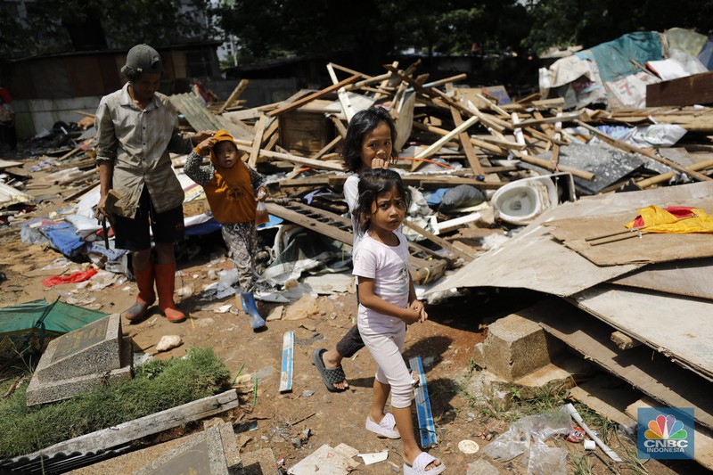 Seorang warga beraktivitas di lokasi puing-puing rumah semi permanen di TPU Menteng Pulo, Jakarta, Jumat (12/12/2025). (CNBC Indonesia/Tri Susilo)