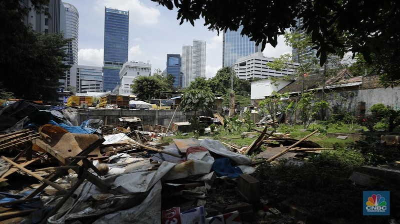 Seorang warga beraktivitas di lokasi puing-puing rumah semi permanen di TPU Menteng Pulo, Jakarta, Jumat (12/12/2025). (CNBC Indonesia/Tri Susilo)