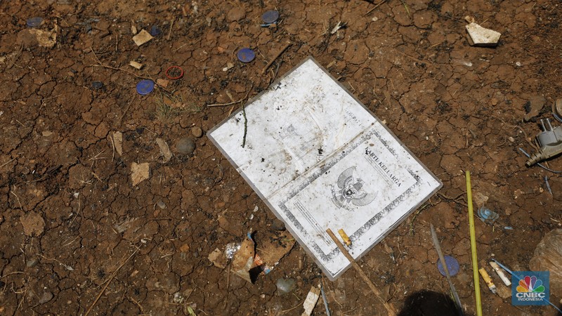 Seorang warga beraktivitas di lokasi puing-puing rumah semi permanen di TPU Menteng Pulo, Jakarta, Jumat (12/12/2025). (CNBC Indonesia/Tri Susilo)