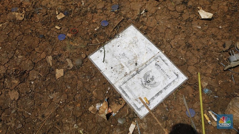 Seorang warga beraktivitas di lokasi puing-puing rumah semi permanen di TPU Menteng Pulo, Jakarta, Jumat (12/12/2025). (CNBC Indonesia/Tri Susilo)