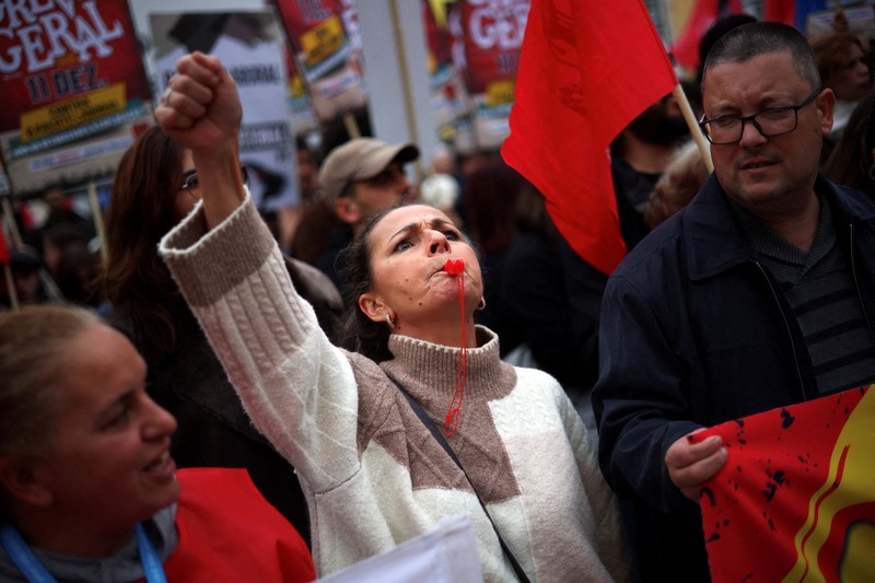 Sebuah poster promosi bergambar kucing terlihat selama demonstrasi pada hari ketika dua serikat pekerja utama, CGTP dan UGT, menyerukan pemogokan umum sebagai protes terhadap rencana pemerintah untuk mereformasi undang-undang ketenagakerjaan, di Lisbon, Portugal, 11 Desember 2025. (REUTERS/Pedro Nunes)
