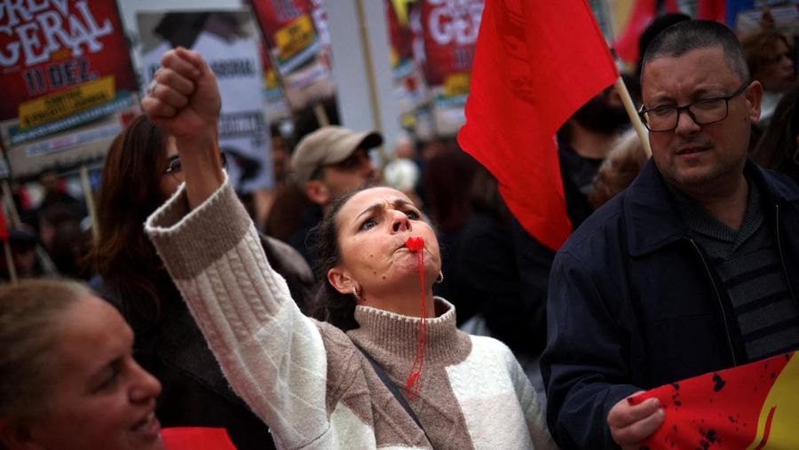 Sebuah poster promosi bergambar kucing terlihat selama demonstrasi pada hari ketika dua serikat pekerja utama, CGTP dan UGT, menyerukan pemogokan umum sebagai protes terhadap rencana pemerintah untuk mereformasi undang-undang ketenagakerjaan, di Lisbon, Portugal, 11 Desember 2025. (REUTERS/Pedro Nunes)
