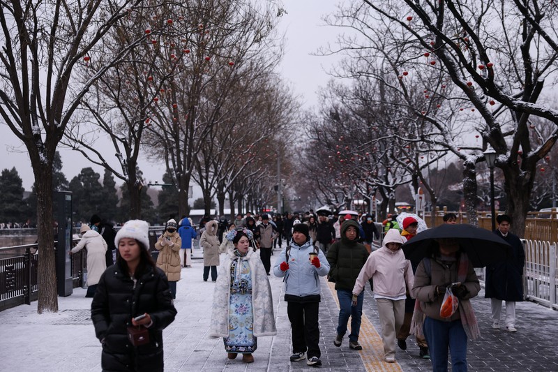 Kota Beijing mulai diselimut salju pada Jumat (12/12). Ini merupakan hujan salju besar pertama pada musim dingin 2025. (REUTERS/Tingshu Wang)