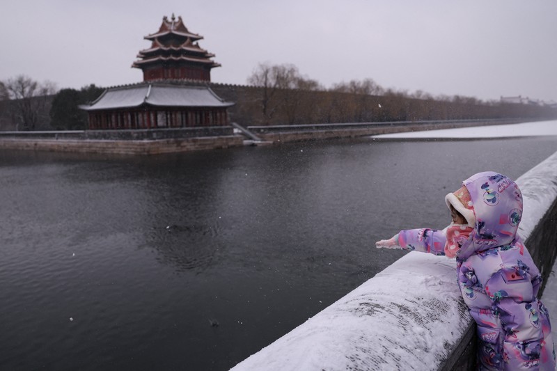Kota Beijing mulai diselimut salju pada Jumat (12/12). Ini merupakan hujan salju besar pertama pada musim dingin 2025. (REUTERS/Tingshu Wang)