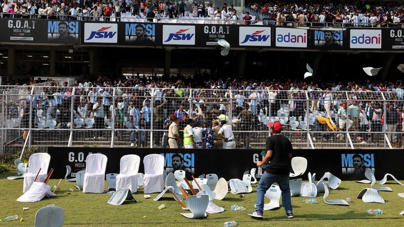 Seorang penggemar merobohkan papan reklame setelah bintang sepak bola Argentina Lionel Messi meninggalkan stadion Vivekananda Yuba Bharati Krirangan selama tur India-nya, Kolkata, India, 13 Desember 2025. (REUTERS/Sahiba Chawdhary)