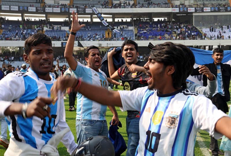 Seorang penggemar merobohkan papan reklame setelah bintang sepak bola Argentina Lionel Messi meninggalkan stadion Vivekananda Yuba Bharati Krirangan selama tur India-nya, Kolkata, India, 13 Desember 2025. (REUTERS/Sahiba Chawdhary)