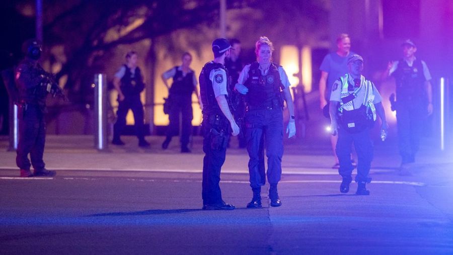Cuplikan layar dari video ini memperlihatkan pemandangan udara dari tubuh-tubuh yang tertutup kain dan darah di tanah, sebuah kendaraan dengan pintu terbuka, dan polisi di lokasi kejadian penembakan di Pantai Bondi di Sydney, Australia, 14 Desember 2025. (NINE NETWORK/SEVEN NETWORK/AUSTRALIAN BROADCASTING CORPORATION/Handout via REUTERS)