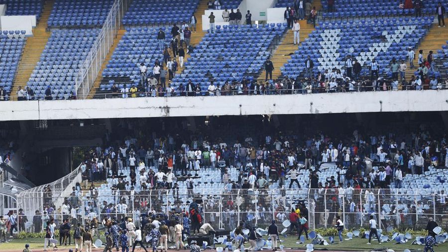 Polisi anti huru hara dikerahkan setelah para penggemar yang kecewa melemparkan kursi ke lapangan usai bintang sepak bola Argentina Lionel Messi meninggalkan stadion saat tur kilatnya ke India, di Vivekananda Yuva Bharati Krirangan, Kolkata, India, 13 Desember 2025. (REUTERS/Sahiba Chawdhary)