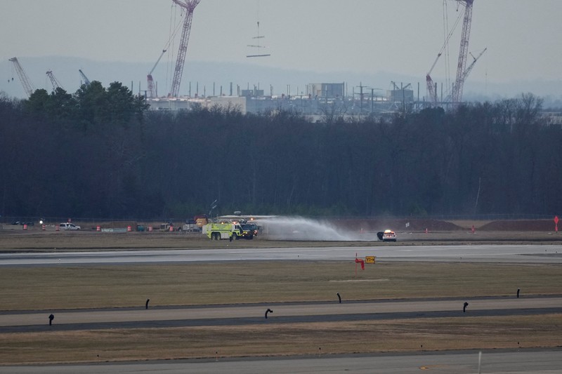 Kendaraan darurat terparkir di landasan pacu setelah penerbangan United Airlines yang seharusnya menuju Tokyo namun terpaksa kembali ke Bandara Internasional Dulles, di Dulles, Virginia, AS, 13 Desember 2025. (REUTERS/Ken Cedeno)