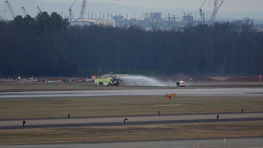 Kendaraan darurat terparkir di landasan pacu setelah penerbangan United Airlines yang seharusnya menuju Tokyo namun terpaksa kembali ke Bandara Internasional Dulles, di Dulles, Virginia, AS, 13 Desember 2025. (REUTERS/Ken Cedeno)