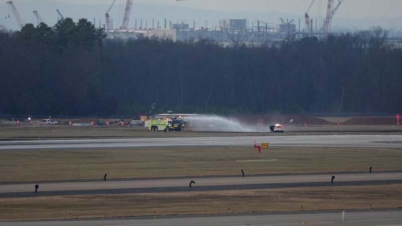 Kendaraan darurat terparkir di landasan pacu setelah penerbangan United Airlines yang seharusnya menuju Tokyo namun terpaksa kembali ke Bandara Internasional Dulles, di Dulles, Virginia, AS, 13 Desember 2025. (REUTERS/Ken Cedeno)