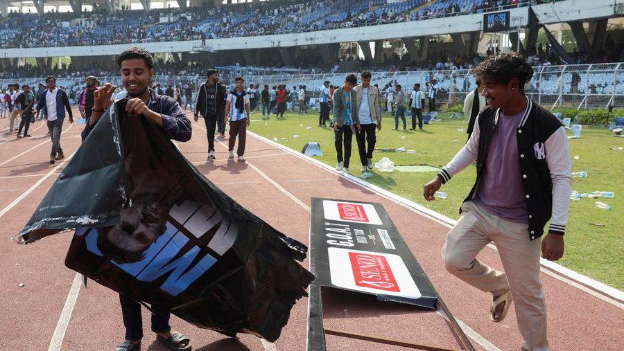 Seorang penggemar merobohkan papan reklame setelah bintang sepak bola Argentina Lionel Messi meninggalkan stadion Vivekananda Yuba Bharati Krirangan selama tur India-nya, Kolkata, India, 13 Desember 2025. (REUTERS/Sahiba Chawdhary)