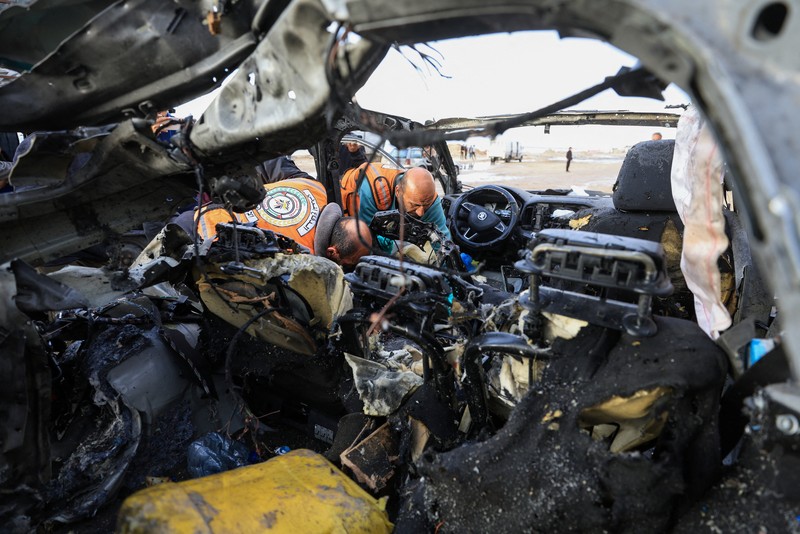 Warga Palestina memeriksa lokasi serangan Israel terhadap sebuah mobil di Kota Gaza, 13 Desember 2025. (REUTERS/Dawoud Abu Alkas)