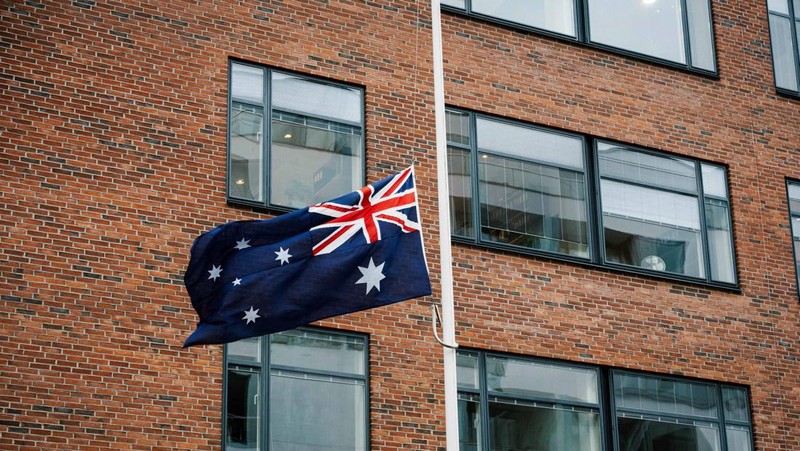 Australia mengibarkan bendera setengah tiang usai penembakan massal di Pantai Bondi yang menewaskan 11 orang, Senin (15/12/2025). Bendera setengah tiang sebagai bentuk duka cita nasional. (via REUTERS/Emil Nicolai Helms)
