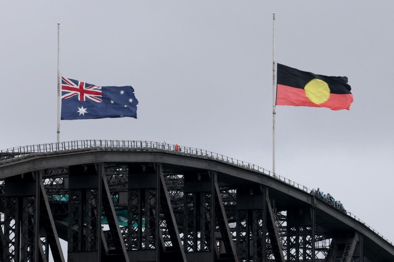 Australia mengibarkan bendera setengah tiang usai penembakan massal di Pantai Bondi yang menewaskan 11 orang, Senin (15/12/2025). Bendera setengah tiang sebagai bentuk duka cita nasional. (via REUTERS/Emil Nicolai Helms)