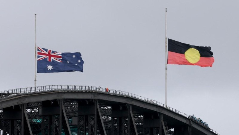 Australia mengibarkan bendera setengah tiang usai penembakan massal di Pantai Bondi yang menewaskan 11 orang, Senin (15/12/2025). Bendera setengah tiang sebagai bentuk duka cita nasional. (via REUTERS/Emil Nicolai Helms)