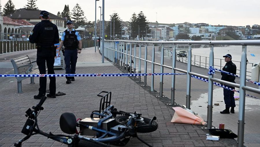 Sebuah tayangan drone menunjukkan salah satu tersangka pelaku penembakan di jembatan penyeberangan, di samping tersangka pelaku penembakan lainnya yang sedang berbaring, sementara para korban tergeletak di tanah, setelah insiden penembakan di Pantai Bondi, Sydney, Australia, 14 Desember 2025, dalam cuplikan layar yang diperoleh dari video media sosial. (@bonusik28 via X/via REUTERS)