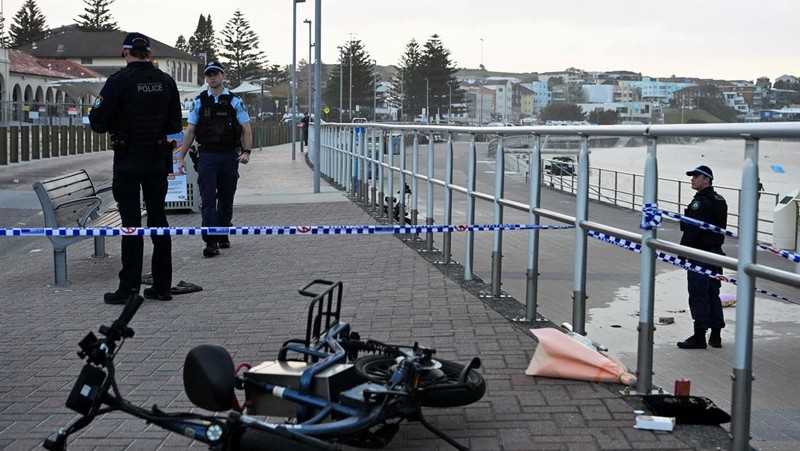 Sebuah tayangan drone menunjukkan salah satu tersangka pelaku penembakan di jembatan penyeberangan, di samping tersangka pelaku penembakan lainnya yang sedang berbaring, sementara para korban tergeletak di tanah, setelah insiden penembakan di Pantai Bondi, Sydney, Australia, 14 Desember 2025, dalam cuplikan layar yang diperoleh dari video media sosial. (@bonusik28 via X/via REUTERS)