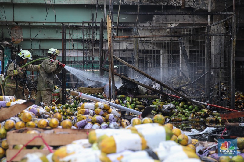 Petugas melakukan pemadaman kebakaran yang melanda Pasar Induk Kramat Jati, Jakarta, Senin (15/12/2025). (CNBC Indonesia/Faisal Rahman)