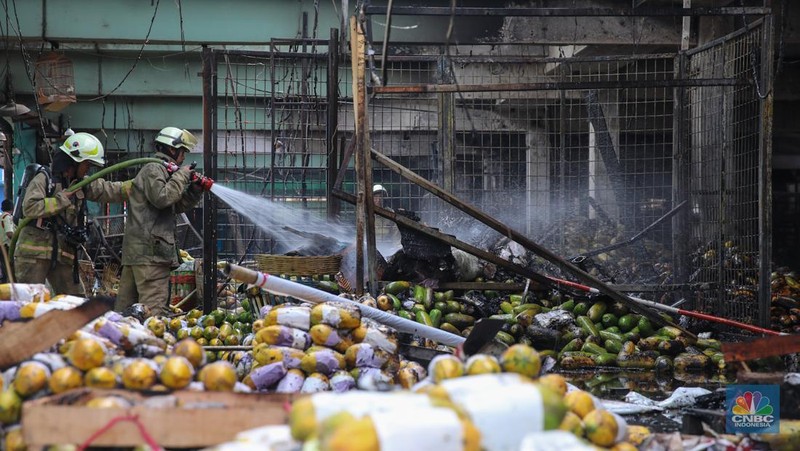 Petugas melakukan pemadaman kebakaran yang melanda Pasar Induk Kramat Jati, Jakarta, Senin (15/12/2025). (CNBC Indonesia/Faisal Rahman)